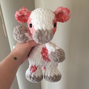Handmade crochet cow snuggler in shades of pink and white